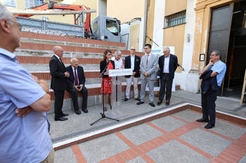 A woman talks in front of the construction of renovations of the The Cultural Centre La Providence and the Théâtre de La Semeuse